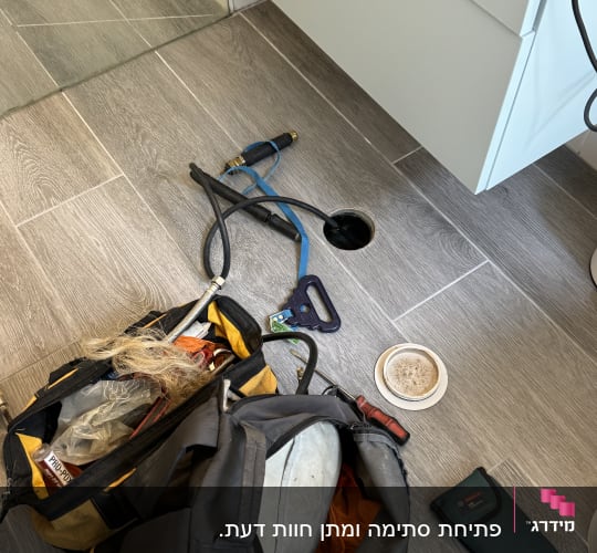 כלי עבודה של אינסטלטור על רצפת חדר אמבטיה